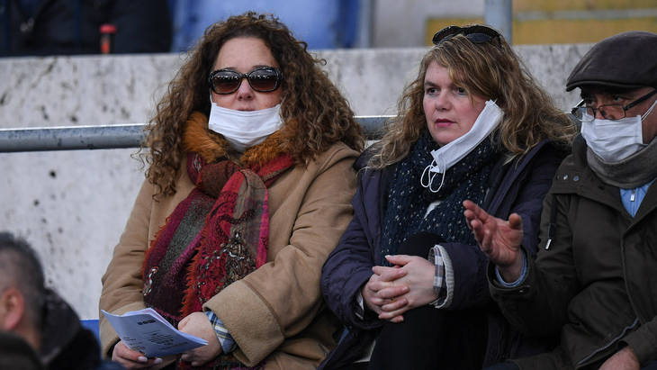 Болельщики в масках на трибунах