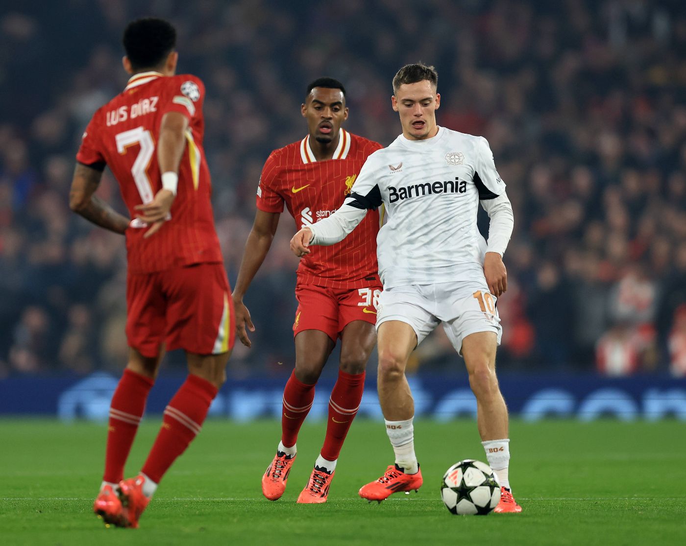 Флориан Вирц против Райана Гравенберха и Луиса Диаса в матче Лиги чемпионов